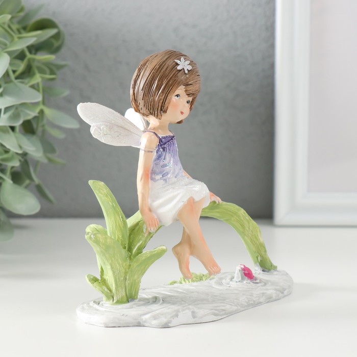 фото Сувенир полистоун "малышка в сиреневом платье с крыльями, сидит у пруда" 12,5х8х12 см