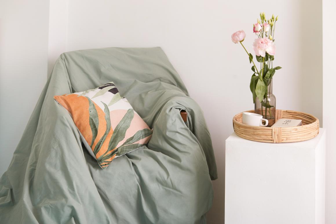 Одеяло и подушка на кресле, цветы, домашняя обстановка