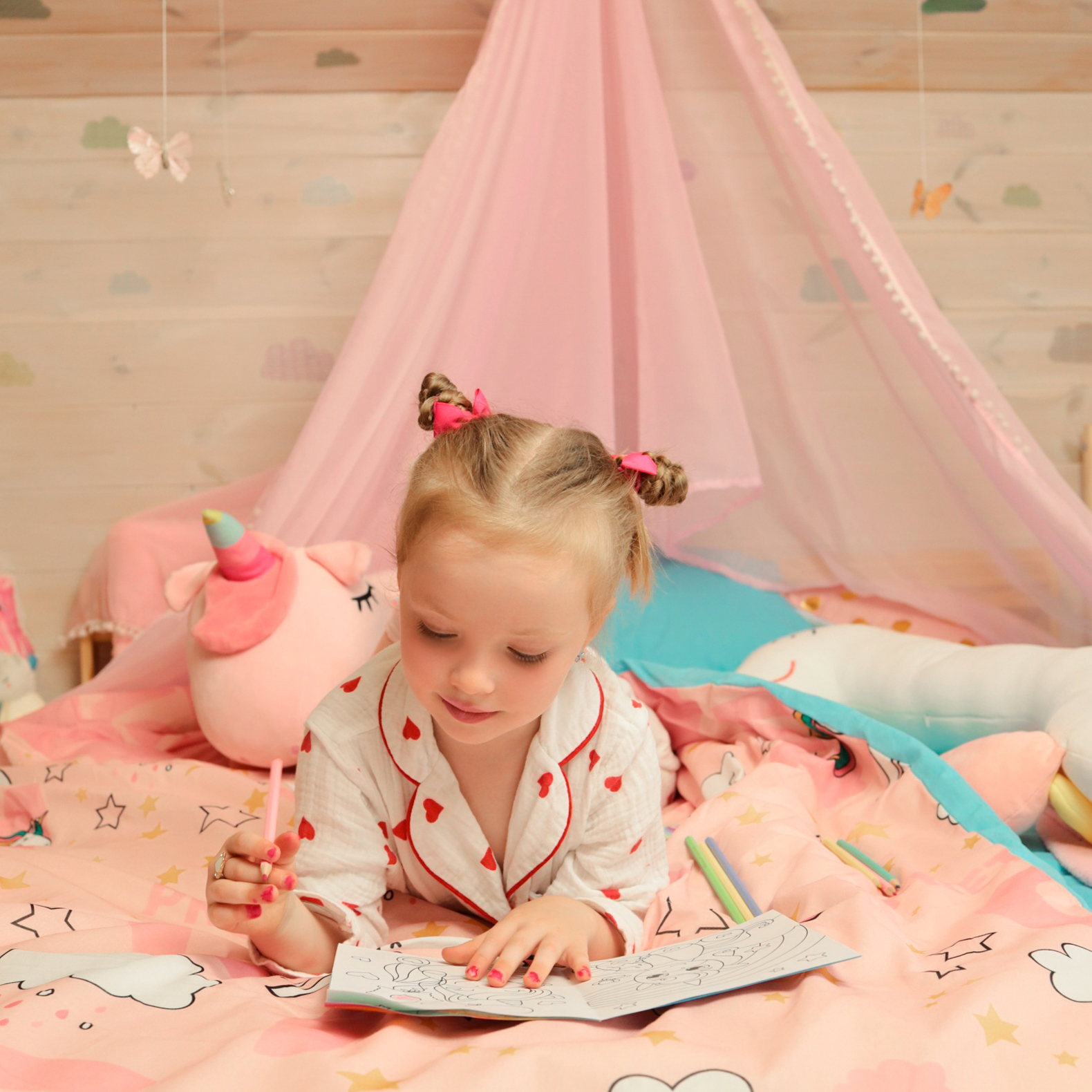 девочка с раскраской на кровати