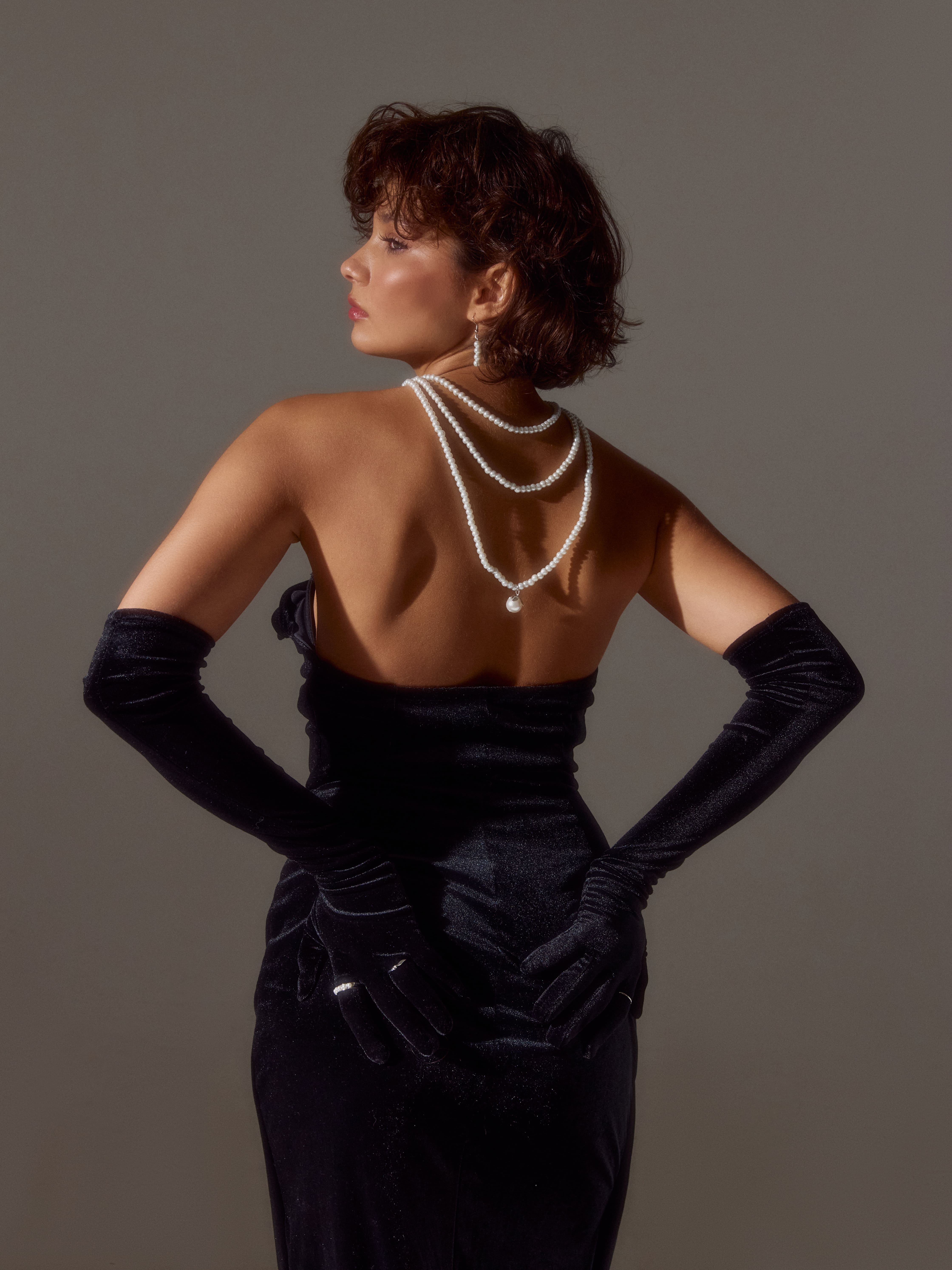 Девушка в чёрном платье с белым жемчугом