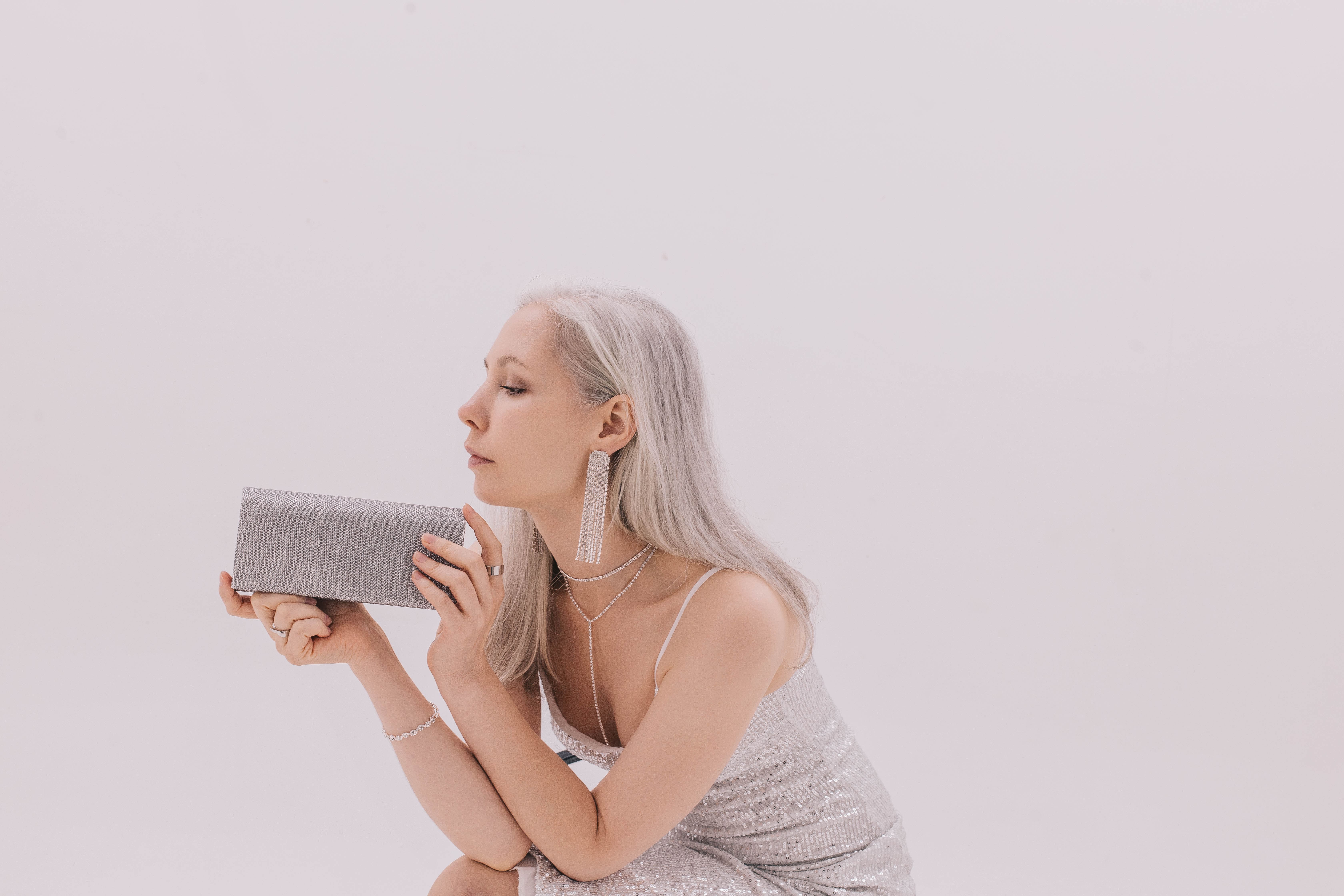 Девушка в серебристом платье с клатчем