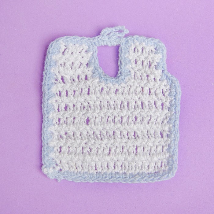 Нагрудник для куклы вязаный, цвет белый с голубой каёмкой